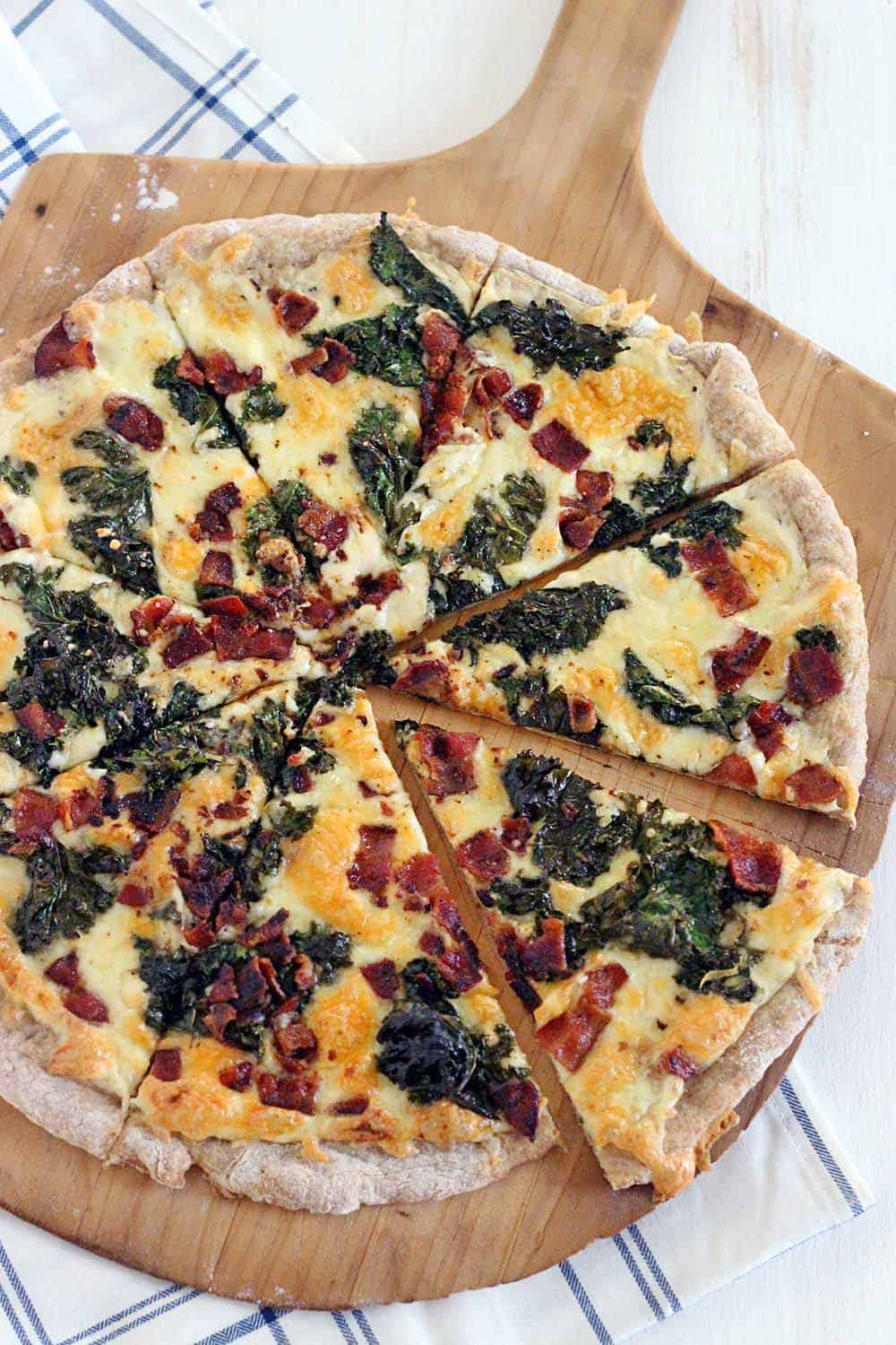 This Bacon and Kale Pizza is topped with super crispy kale and bacon pieces. This recipe comes together with only 5 ingredients in under 30 minutes!