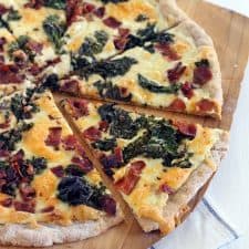 This Bacon and Kale Pizza is topped with super crispy kale and bacon pieces. This recipe comes together with only 5 ingredients in under 30 minutes!