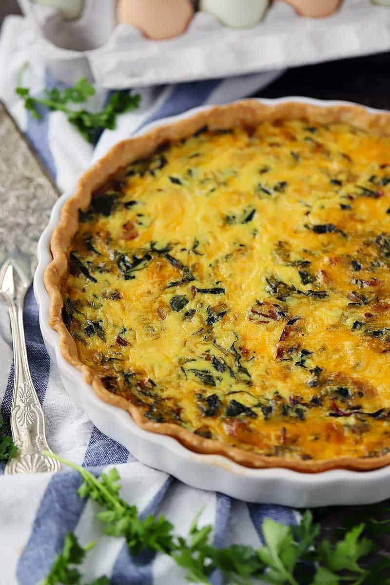 Close up photo of a bacon and swiss chard quiche.