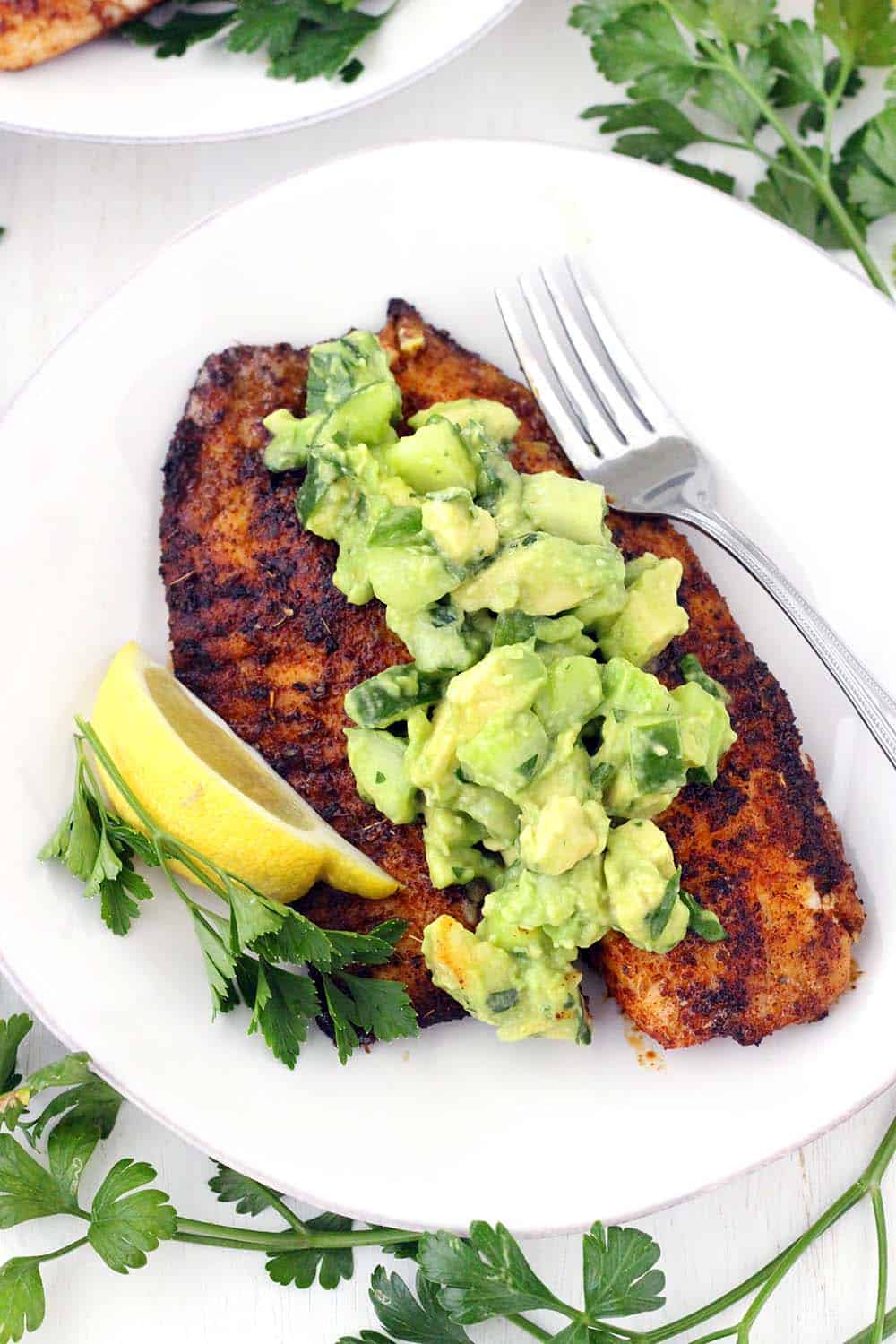 This super flavorful Blackened Tilapia comes together in less than 10 minutes!! Topped with a cool and refreshing avocado cucumber salsa, this is the perfect quick and easy low-carb recipe. Paleo, gluten free, and whole30 compliant.