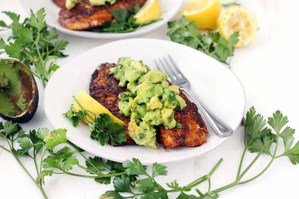 This super flavorful Blackened Tilapia comes together in less than 10 minutes!! Topped with a cool and refreshing avocado cucumber salsa, this is the perfect quick and easy low-carb recipe. Paleo, gluten free, and whole30 compliant.