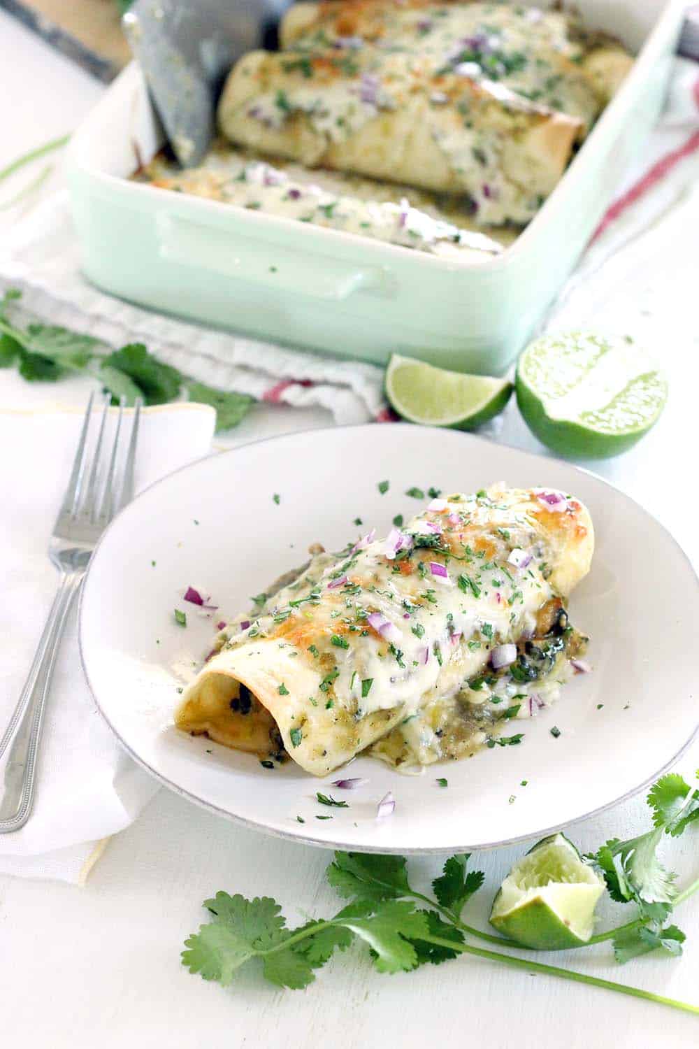 These Chicken and Spinach Enchiladas Verdes are my FAVORITE enchiladas! The recipe is freezable and packed with healthy greens, the chicken is marinated in a delicious jalape&ntilde;o garlic mixture, and they're topped with jarred roasted tomatillo salsa for a quick and easy shortcut.
