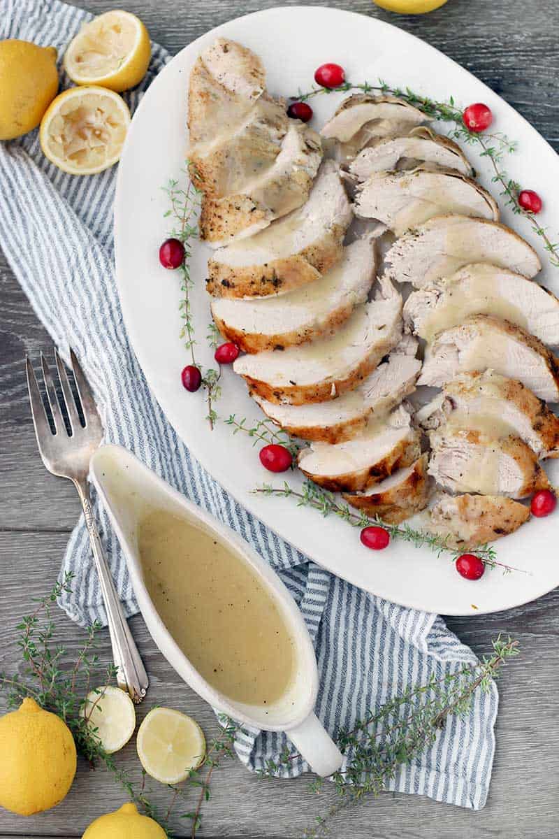 Overhead photo of a platter of turkey and gravy and a gravy boat on the side.