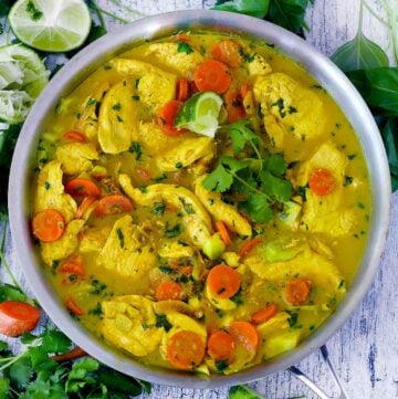 Square photo of coconut chicken curry in a skillet.