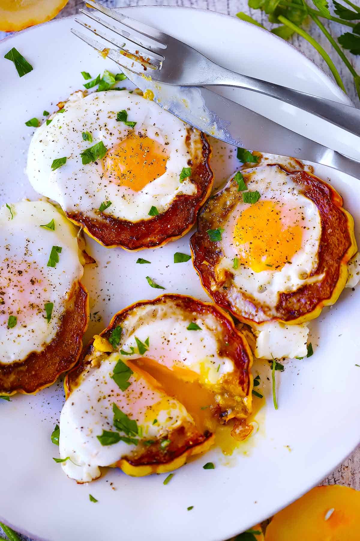 Overhead photo of delicata squash egg in a holes on a white plate.