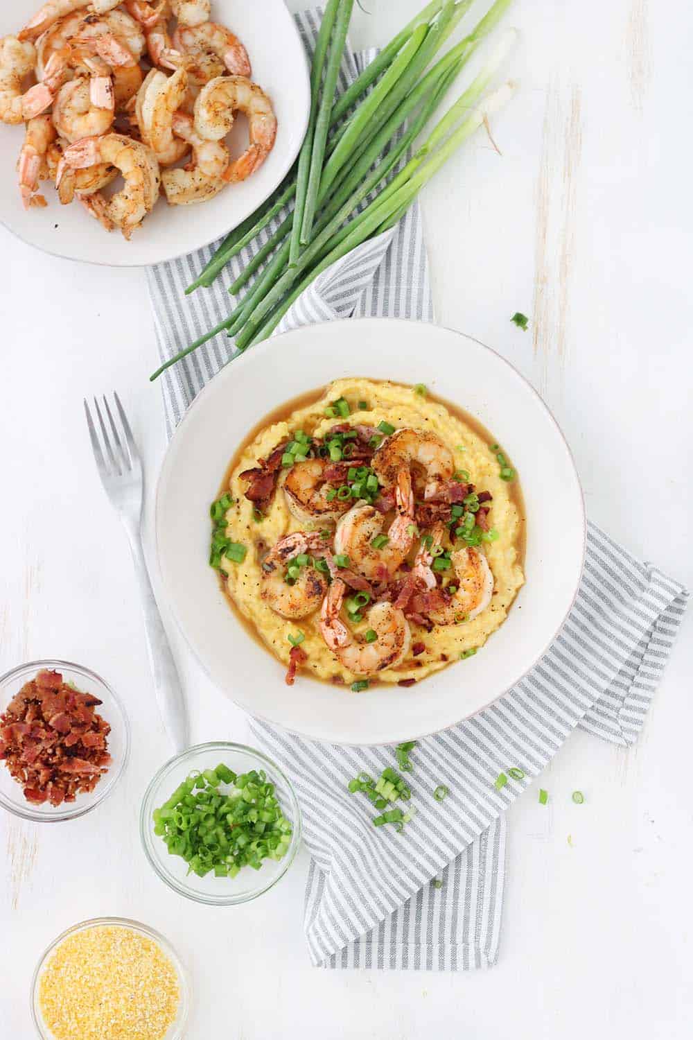 This classic Shrimp and Grits recipe is easy to make and is such delicious Southern comfort food! The cheesy grits are cheap and gluten free, and make an excellent base for the flavorful shrimp and crumbled bacon.