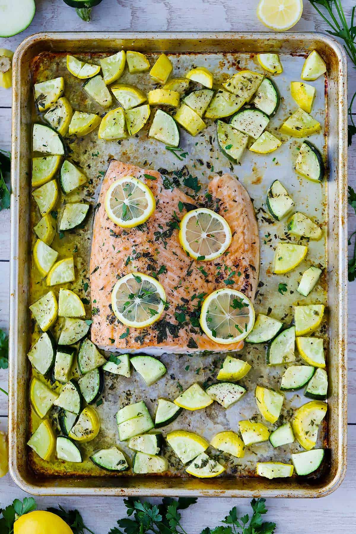 An overhead shot of garlic butter sheet pan salmon with zucchini and summer squash