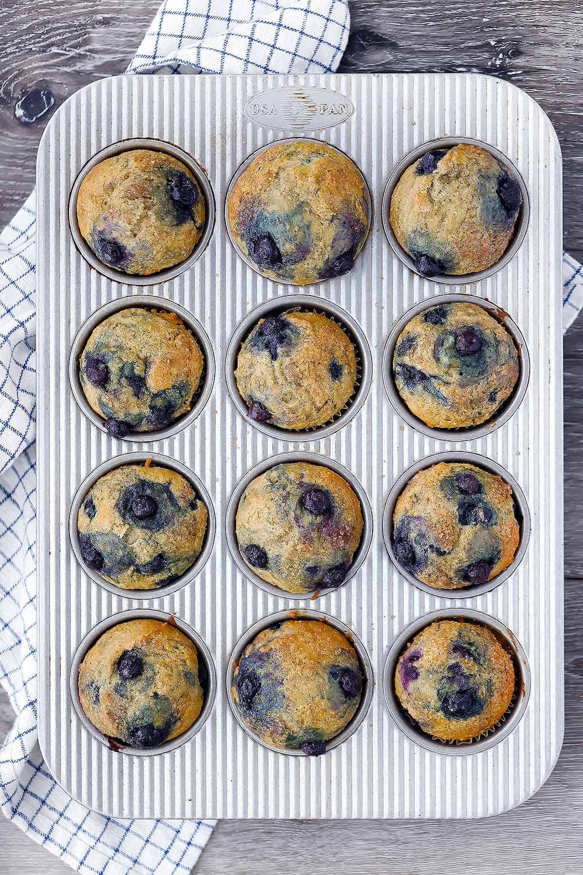 Overhead photo of a muffin pan with healthy blueberry muffins.