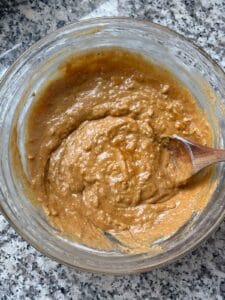 The batter for healthy pumpkin bread in a bowl, showing the texture with no dry spots after just combining with a spoon.