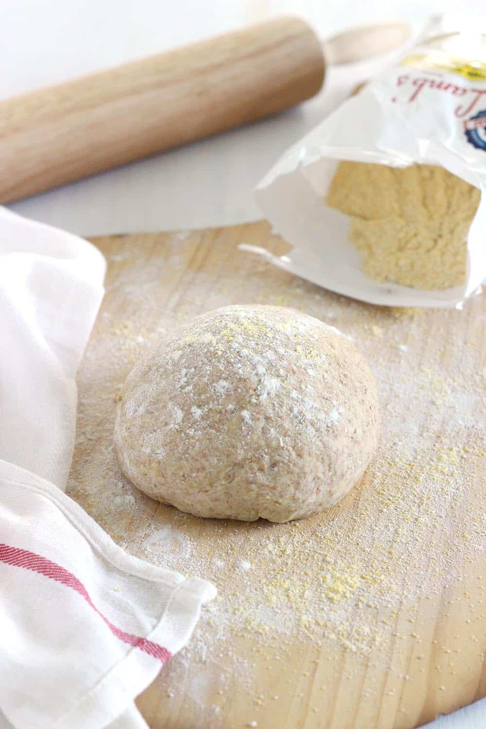 Whole wheat pizza dough on a cutting board.