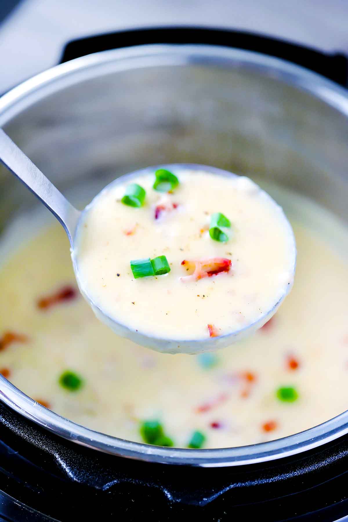 A ladle full of baked potato soup in an instant pot.