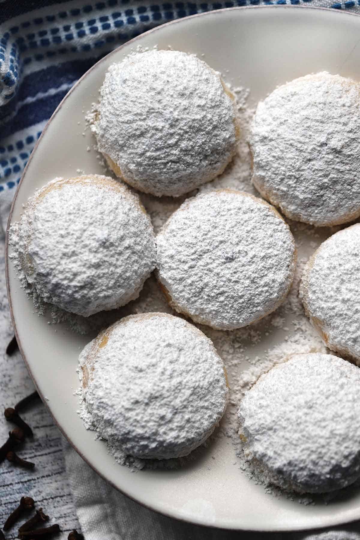 Overhead photo of Kourabiedes, Greek butter cookies, covered in powdered sugar.