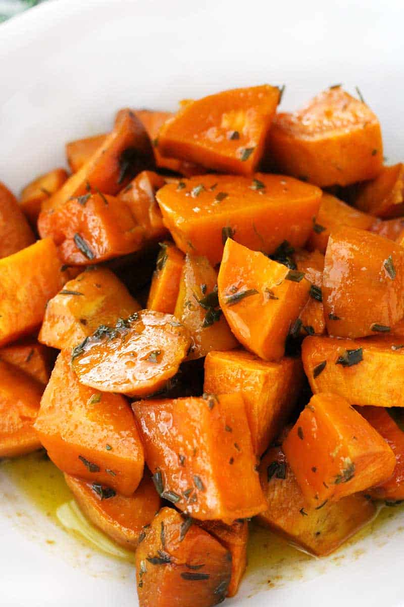 These Glazed Sweet Potatoes are coated in a mixture of melted butter, fresh rosemary, and maple syrup, then baked in the oven until super tender. They're not too sweet, and they're the perfect vegetarian, gluten-free side dish!