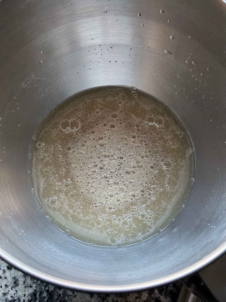 Yeast creating bubbles in warm water and honey.