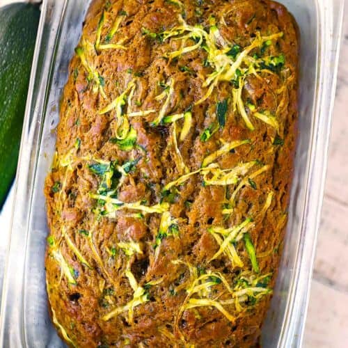 Square photo of zucchini bread in a glass loaf pan.