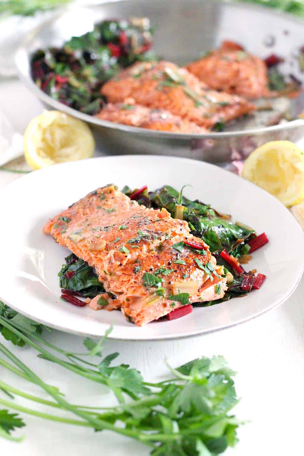 One Pan Garlic Butter Salmon and Swiss Chard- This healthy, gluten-free, low-carb recipe comes together in only 20 minutes! Can easily be made paleo or whole30 compliant by using ghee instead of butter.