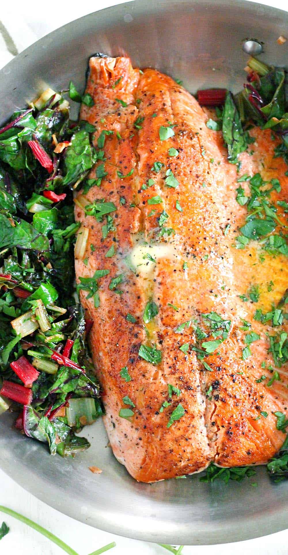 One Pan Garlic Butter Salmon and Swiss Chard- This healthy, gluten-free, low-carb recipe comes together in only 20 minutes! Can easily be made paleo or whole30 compliant by using ghee instead of butter.