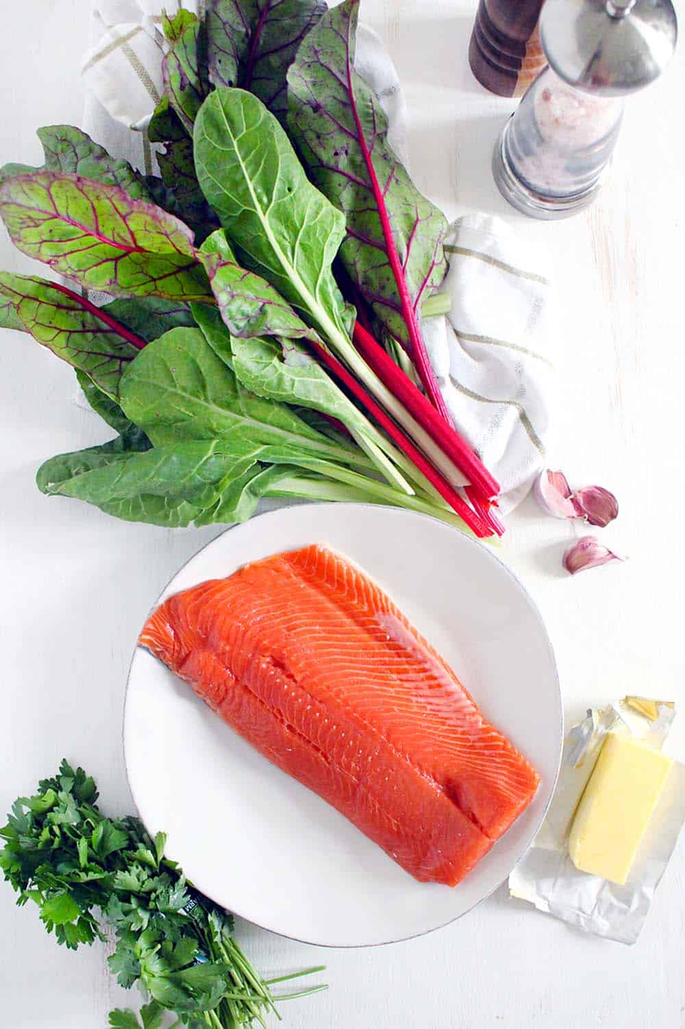 One Pan Garlic Butter Salmon and Swiss Chard- This healthy, gluten-free, low-carb recipe comes together in only 20 minutes! Can easily be made paleo or whole30 compliant by using ghee instead of butter.