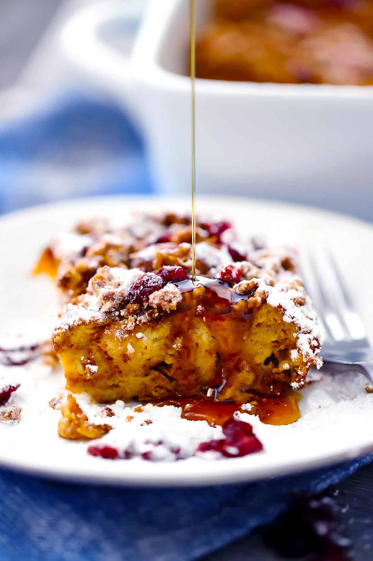 Drizzling maple syrup on a slice of pumpkin french toast casserole.