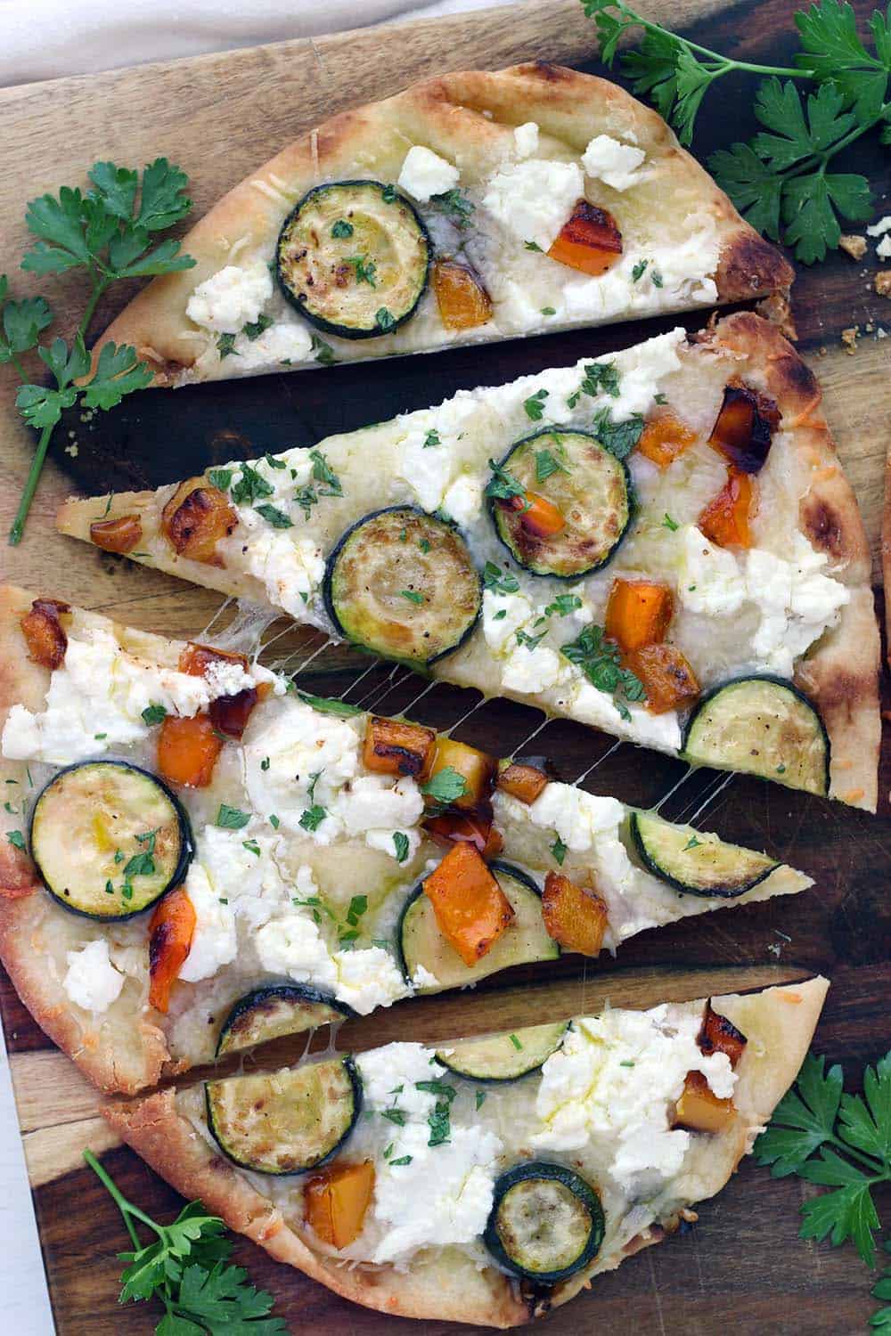 This vegetarian Sautéed Vegetable and Goat Cheese Naan Pizza recipe comes together in only 20 minutes for an easy weeknight dinner! Tip: place the baking rack in the lower half of the oven for a crisp crust.