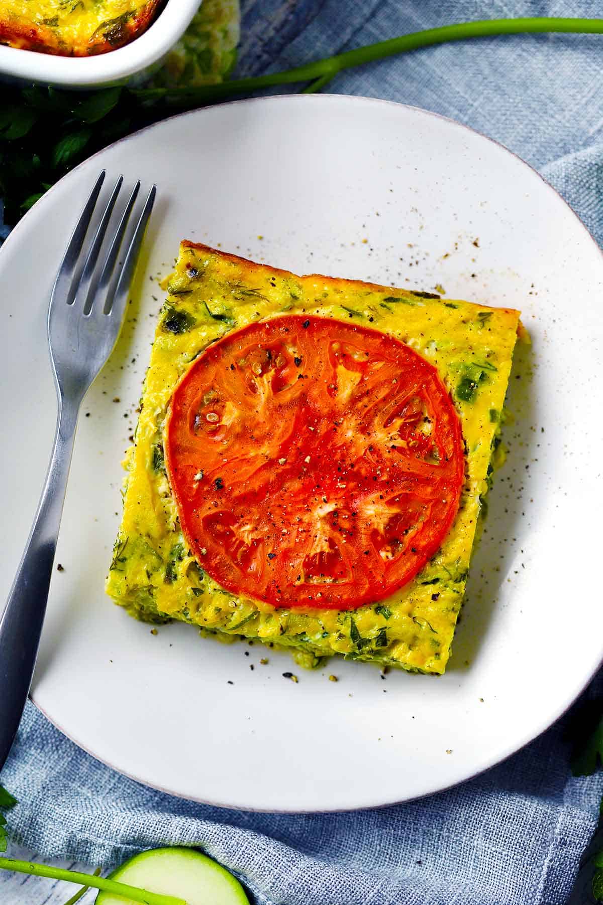 Overhead photo of a slice of sfougato (Greek Zucchini Casserole) on a plate.