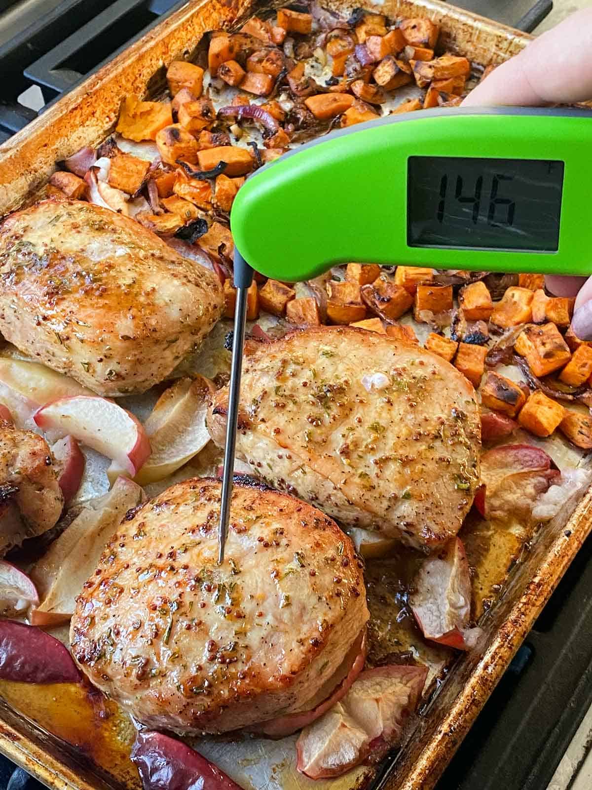 Taking the temperature of a boneless pork chop with a meat thermometer reading 146 degrees F.