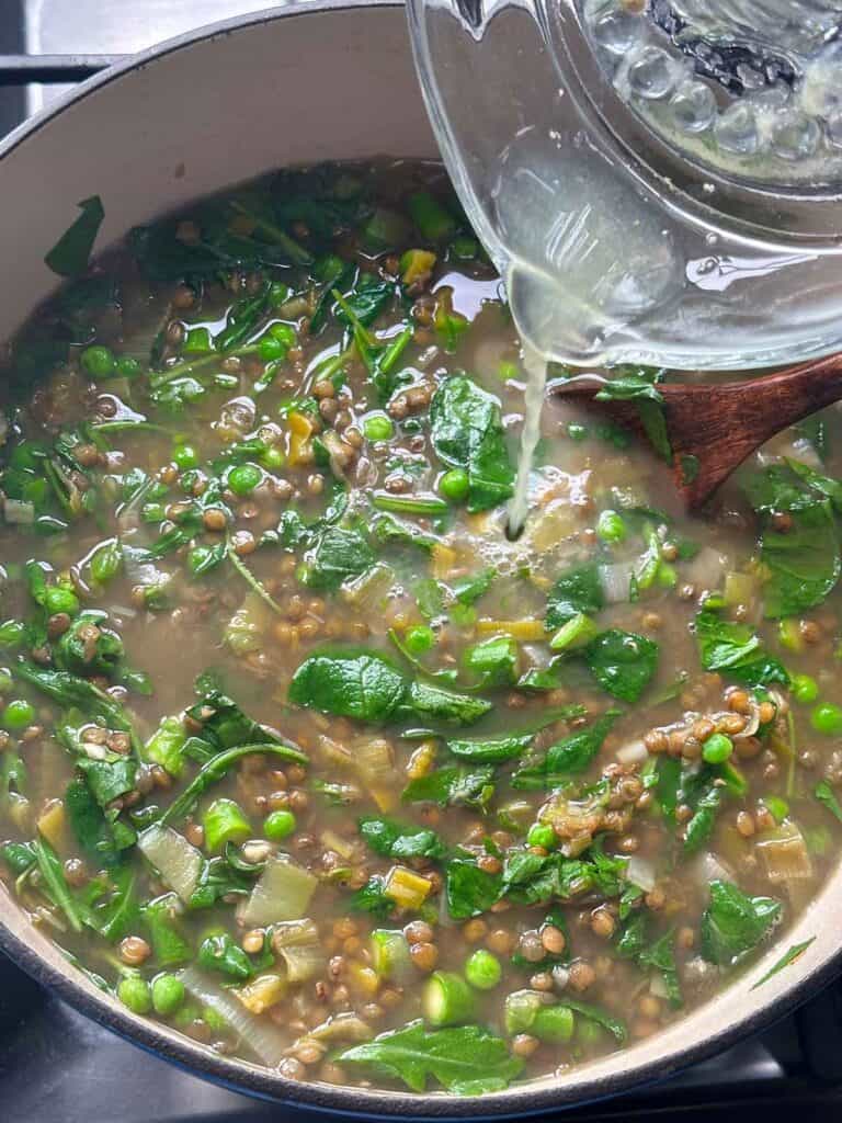 Adding fresh lemon juice at the end of cooking spring lentil vegetable soup.
