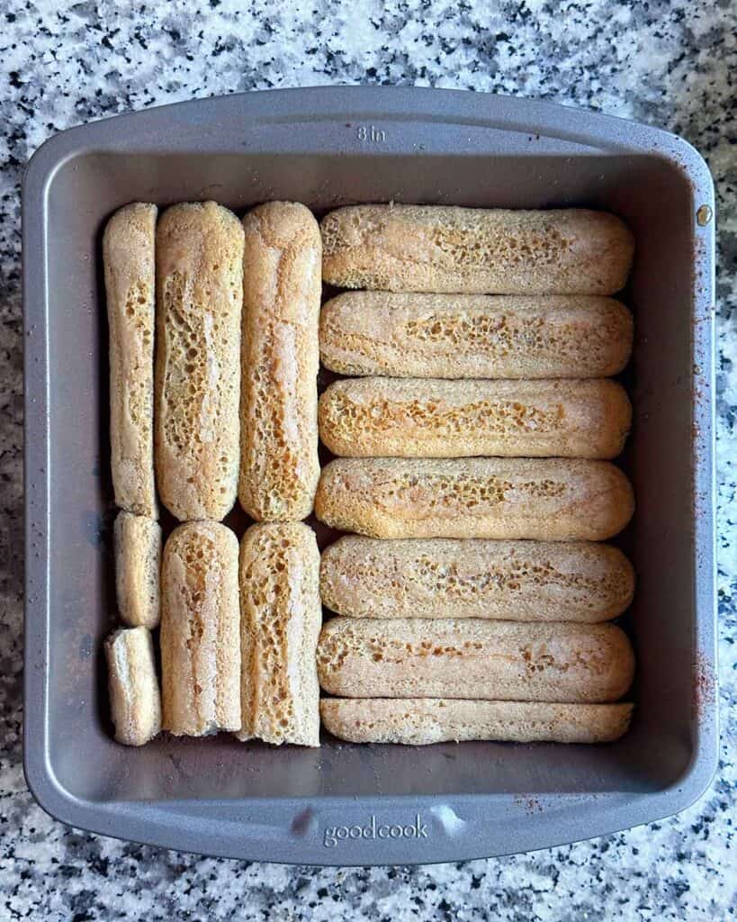 First layer of pumpkin chai tiramisu of dipped ladyfingers.