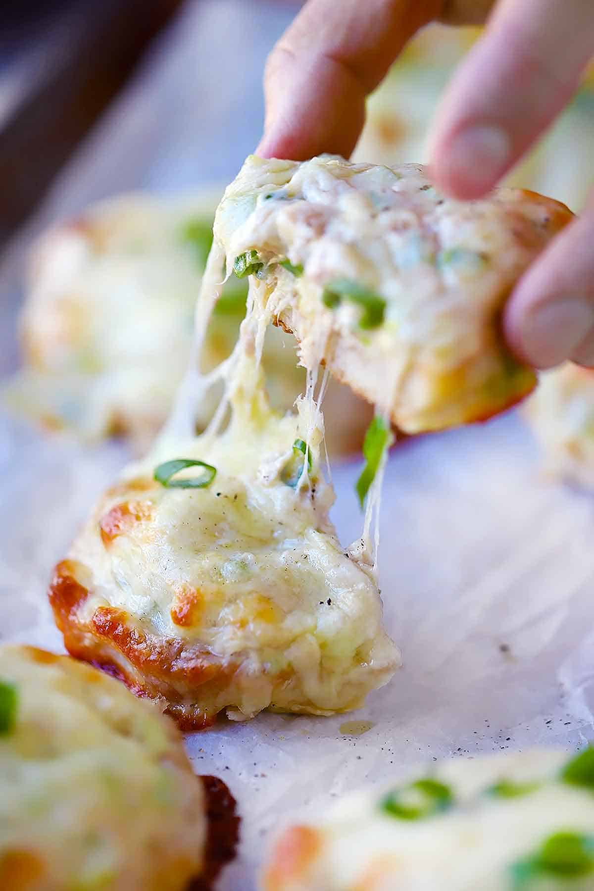 Tuna melt cut in half with melty cheese being pulled.
