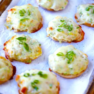 Square photo of English Muffin tuna melts on a baking sheet.