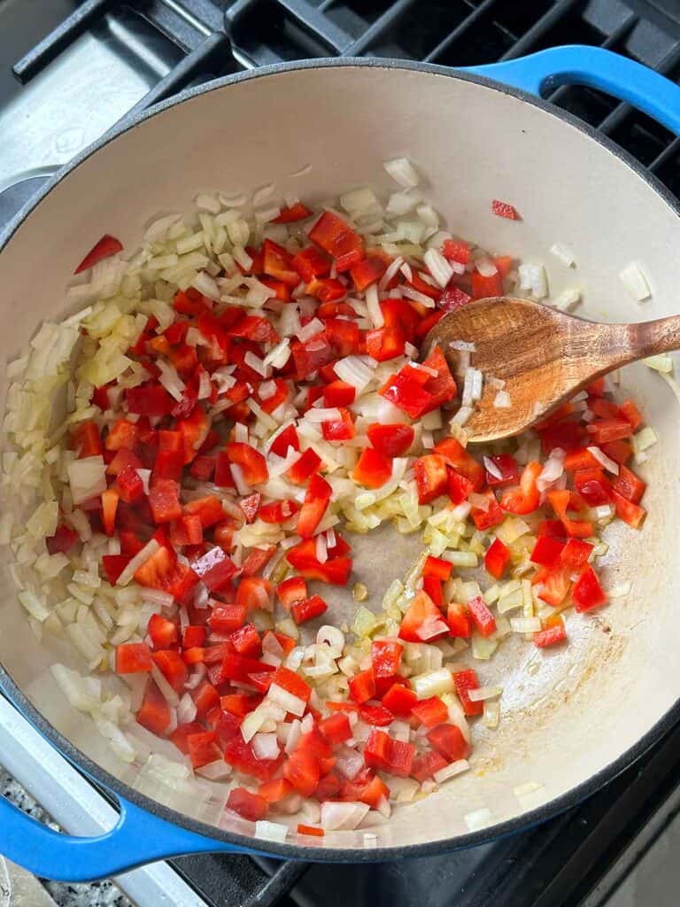 Sautéing red bell peppers and onions in a Dutch oven for turkey chili.