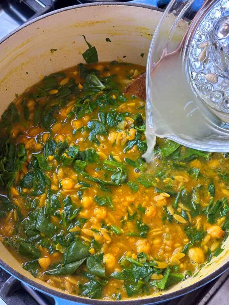 Adding lemon juice to turmeric soup.