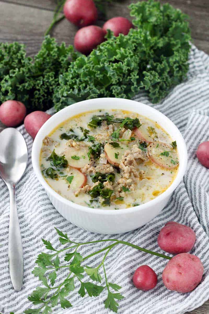 The Olive Garden's famous Zuppa Toscana is so easy to make from scratch at home with only a few ingredients! A creamy, gluten-free soup with Italian sausage, potatoes, and kale.